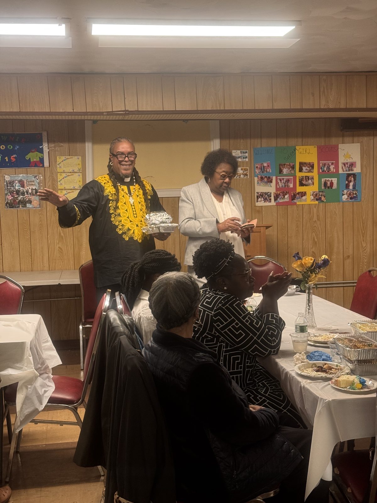 People gathered at tables in the fellowship hall for the anniversary meal